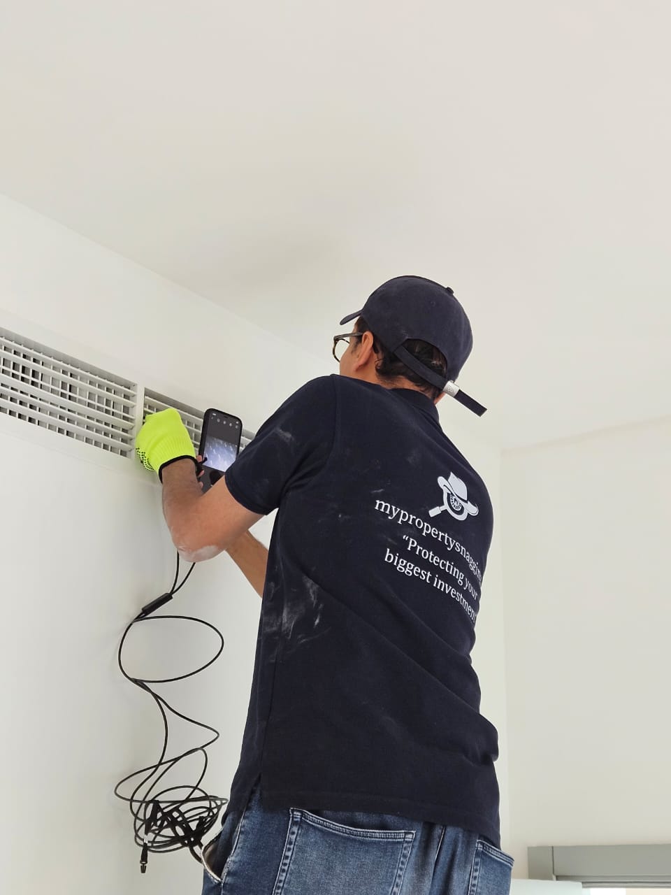 Dubai high-rise snagging — engineer inspecting AC vent and HVAC grille during handover